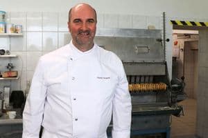 Florian Mangold vor der Baumkuchenmaschine des Betriebs, die schon vor 40 Jahren von seinem Schwiegervater angeschafft wurde.