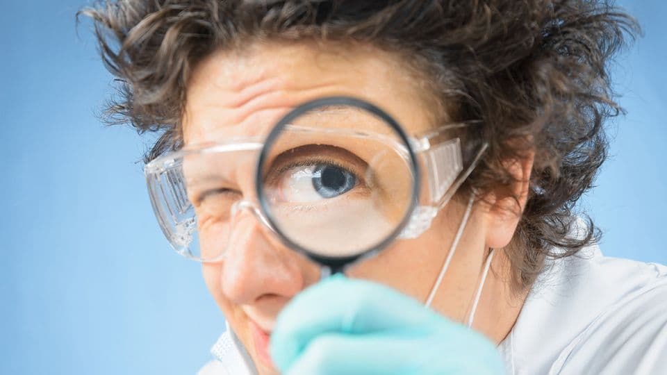 verrückter Professor nimmt etwas unter die Lupe
Crazy  scientist looks through a magnifying glass