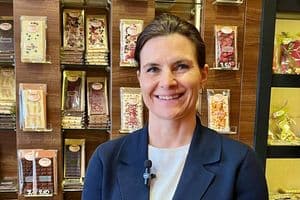 Tafelschokoladen, Eis und Pralinen verkaufen die Mangolds in einem kleinen Raum neben dem Café. Konditormeisterin Cornelia Mangold vor der Wand, die nur einen Teil des Angebots abbildet.