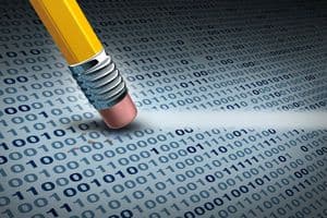 Jemand lässt ein Stift mit Radiergummi über einen Datensatz gleiten und löscht dabei Informationen.