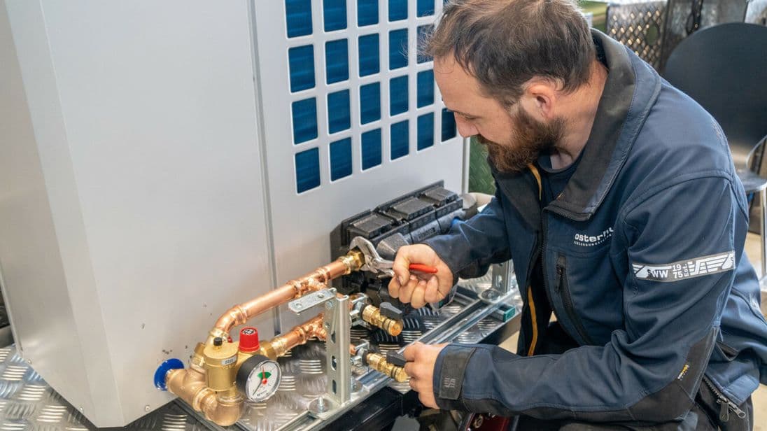 Fabian von der Lage mit letzten Handgriffen an der mobilen Wärmepumpe.