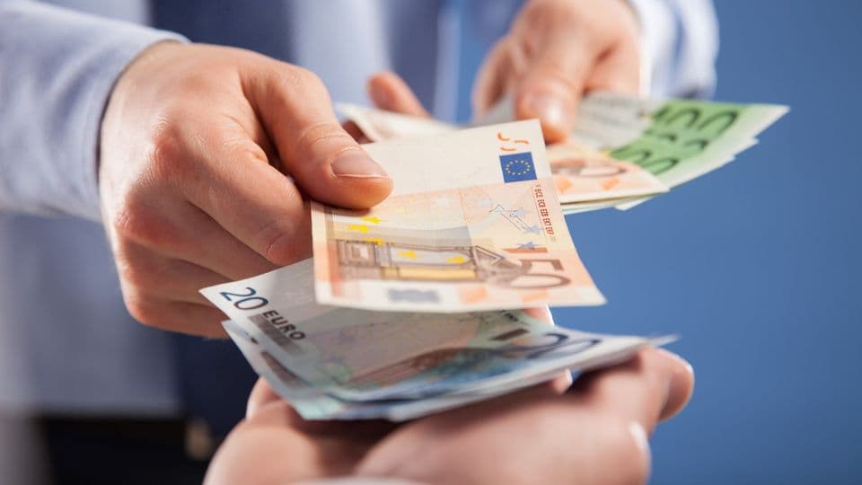 Geschäftsmann übergibt Euroscheine.