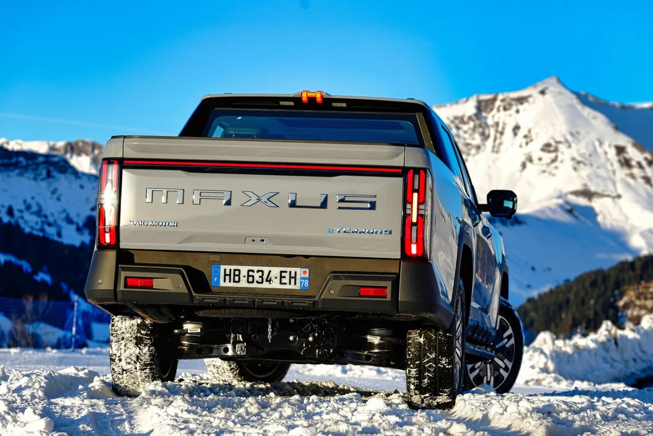 Der neue E-Pick-up eTerron 9 von Maxus ist von hinten auf schneebedecktem Untergrund zu sehen. Im Hintergrund erstreckt sich eine Berglandschaft.