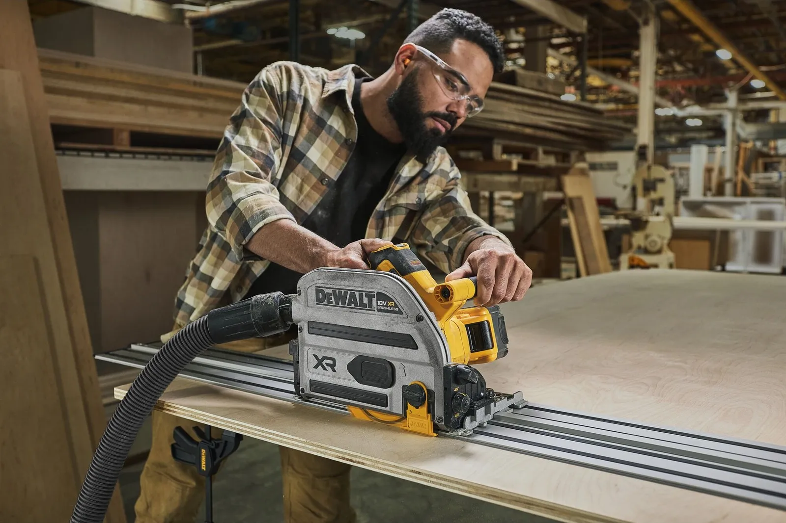 Ein Mann sägt mit der 18 V Akku-Tauchkreissäge von Dewalt ein Brett.