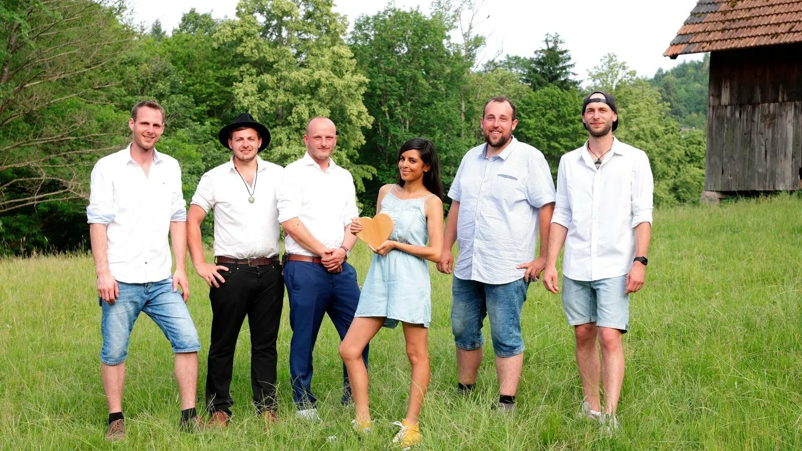 Gruppenfoto von Collien Ulmen-Fernandes und fünf jungen Männern auf einer Wiese.