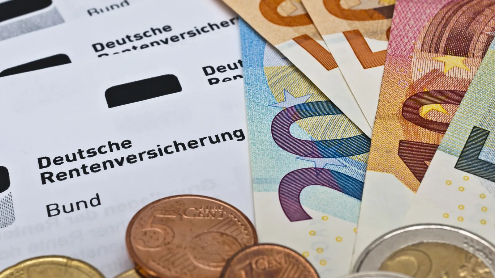 Ein paar Euro-Scheine und Münzen liegen auf einem Dokument.