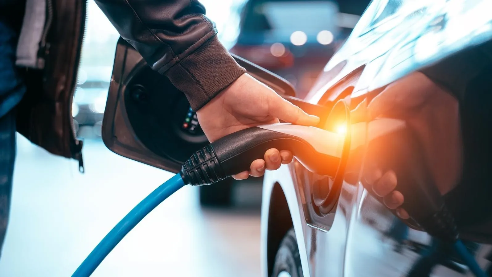 Closes up Human hand is holding Electric Car Charging connect to Electric car