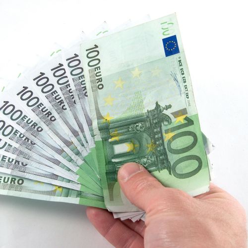 Jemand hält 10 Geldscheine in der Hand – insgesamt sind es 1000 Euro.