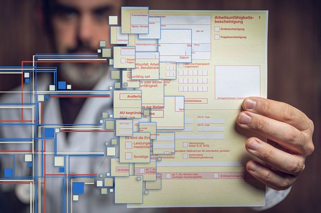 Arzt hält eine elektronische Arbeitsunfähigkeitsbescheinigung 