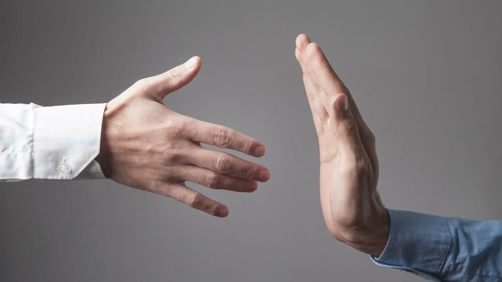 Zwei Hände zeigen unterschiedliche Gesten: Eine Hand ist zum Händeschütteln ausgestreckt, die andere signalisiert mit einer Stoppgeste Ablehnung.
