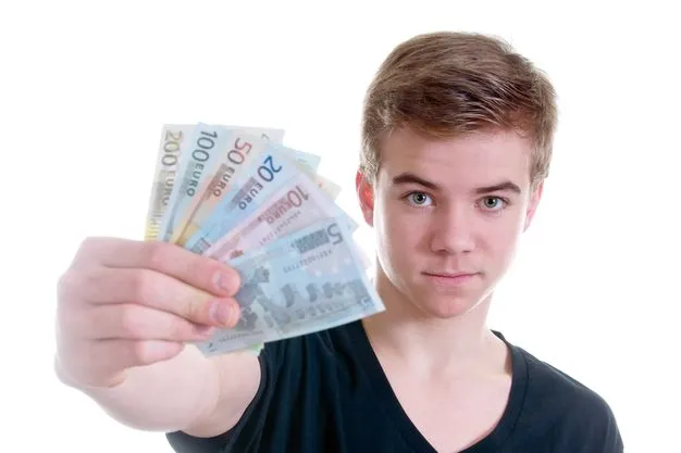Ein junger Mann hält eine Reihe von Euroscheinen in die Kamera und guckt ernst