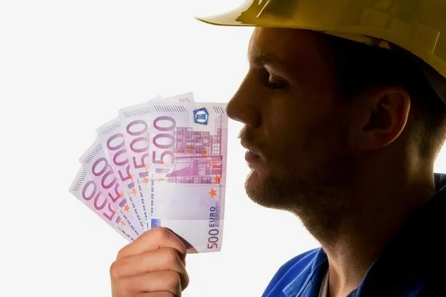 Das Gesicht eines Handwerkers, der einen gelben Schutzhelm trägt, ist von der Seite zu sehen. Er hält sich mehrere 500 Euro Scheine vor das Gesicht.
