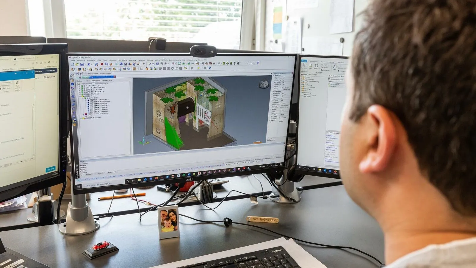 Ein Mann sitzt vor einem PC. Der PC-Bildschirm zeigt ein illustriertes Projekt von einem Spielplatz.