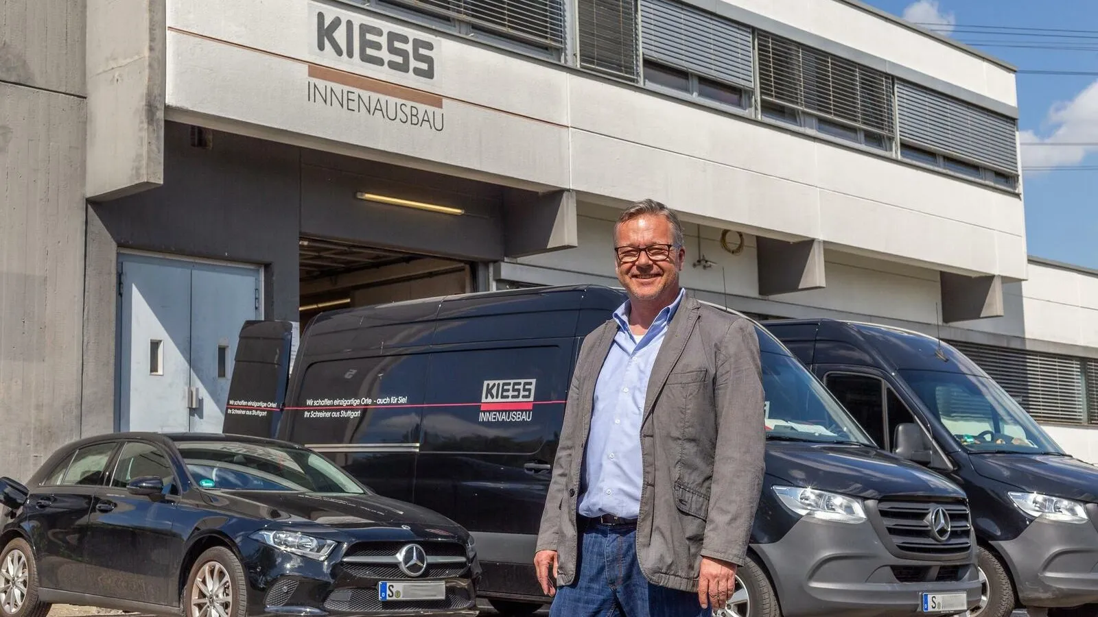 Alfred Kiess steht vor drei schwarzen Firmenfahrzeugen.