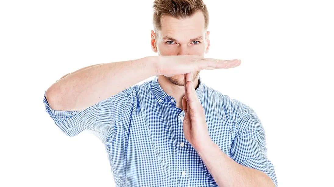 Mann nimmt sich Auszeit und macht Time-out-Zeichen