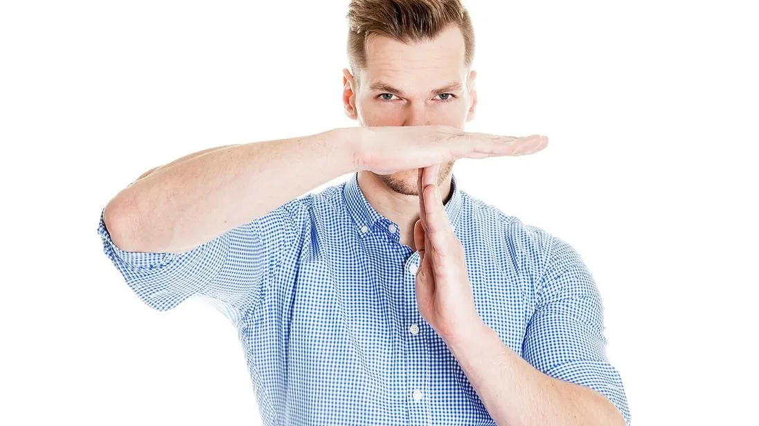 Mann nimmt sich Auszeit und macht Time-out-Zeichen