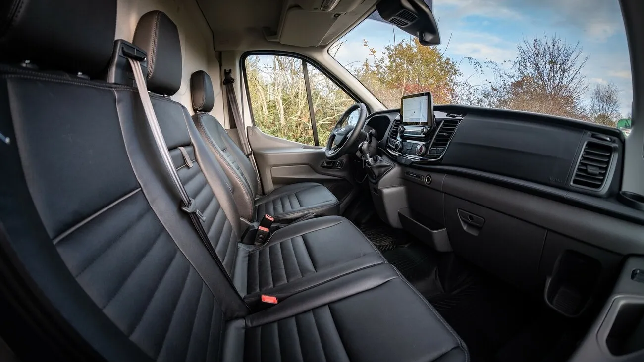 Sitzbank im Inneren des Ford Transit Trail 4x4 mit schwarzen Kunstledersitzen.