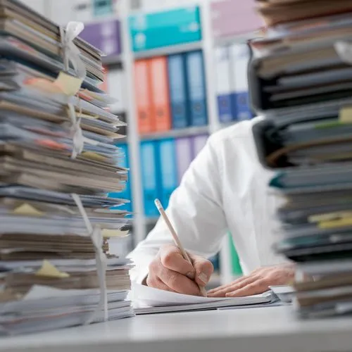 Unterlagen stapeln sich auf dem Schreibtisch eines Unternehmers