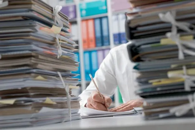Unterlagen stapeln sich auf dem Schreibtisch eines Unternehmers