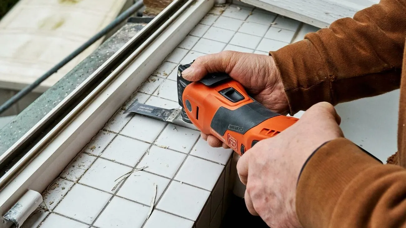 Ein Handwerker arbeitet mit dem Fein Multimaster 700 an der Innenseite eines Fensters.