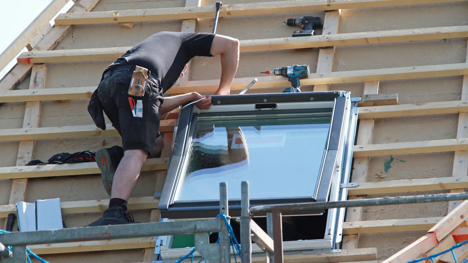 Handwerker baut ein neues Dachfenster ein.