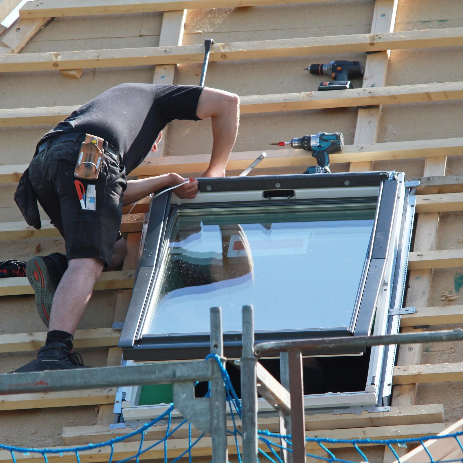 Handwerker baut ein neues Dachfenster ein.