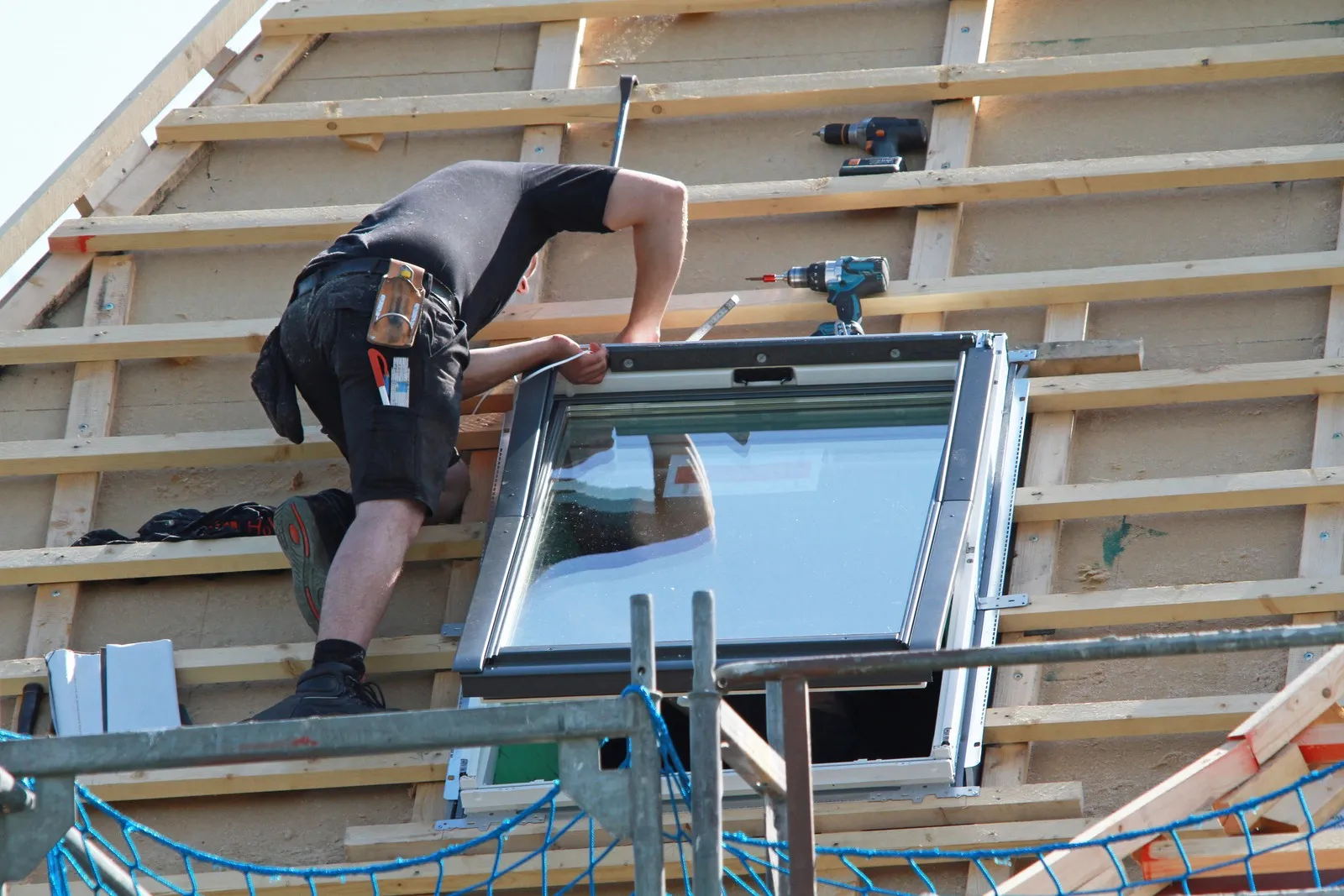 Handwerker baut ein neues Dachfenster ein.