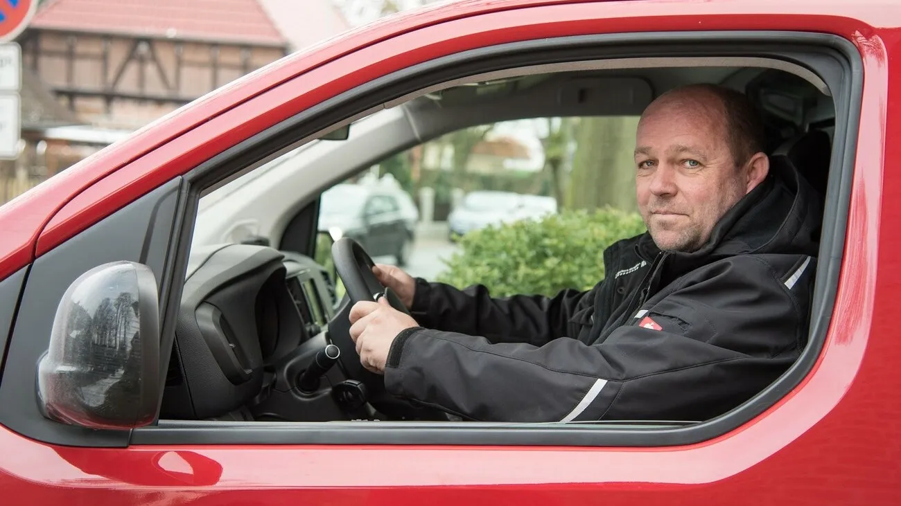 Jens Meyer im Citroen Jumpy mit geöffnetem Fenster, fotografiert von der Fahrertür.