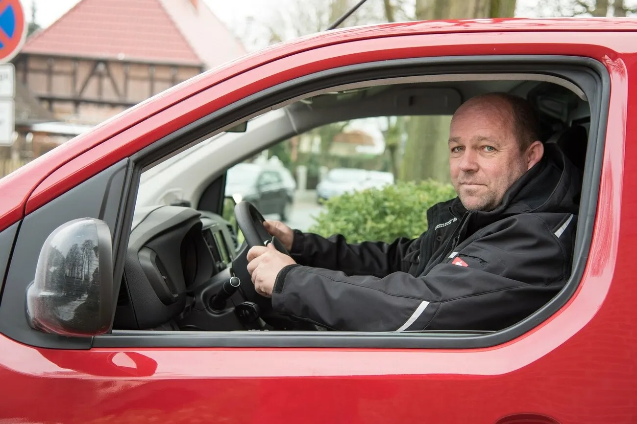 Jens Meyer im Citroen Jumpy mit geöffnetem Fenster, fotografiert von der Fahrertür.