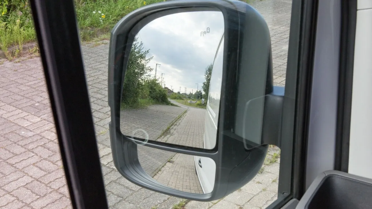 Nahaufnahme des linken Seitenspiegels des VW Crafters aus Fahrerperspektive.