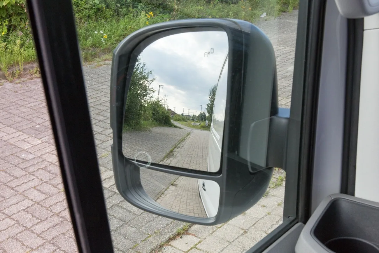 Nahaufnahme des linken Seitenspiegels des VW Crafters aus Fahrerperspektive.