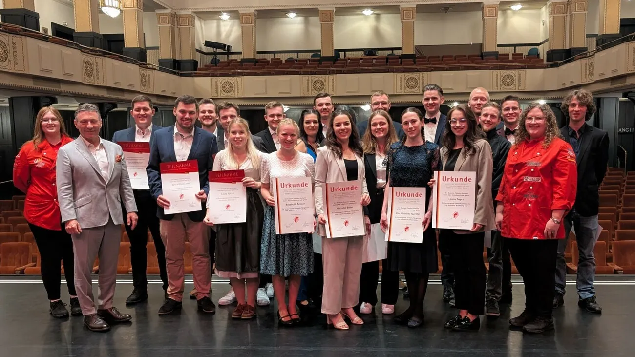 Die besten Fleischer und Fleischereifachverkäuferinnen stehen für ein Gruppenfoto zusammen. Sie halte ihre Urkunden in den Händen.