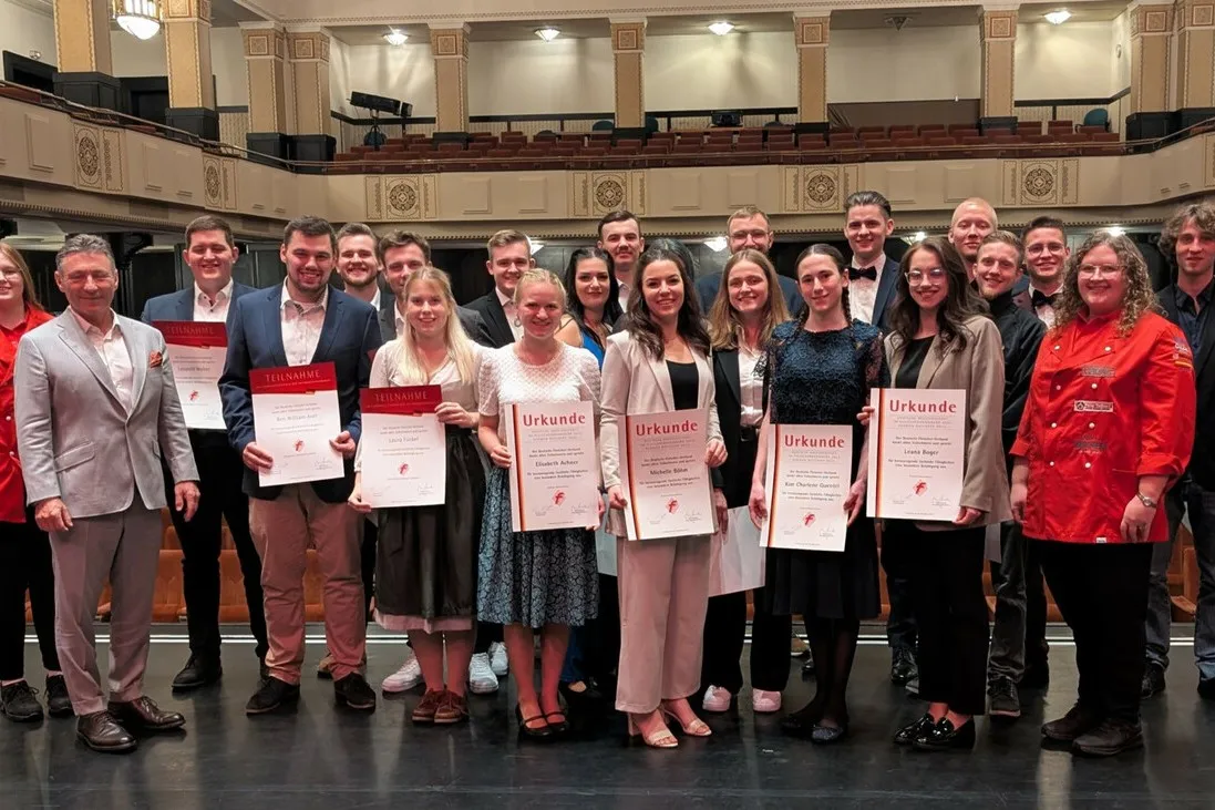 Die besten Fleischer und Fleischereifachverkäuferinnen stehen für ein Gruppenfoto zusammen. Sie halte ihre Urkunden in den Händen.