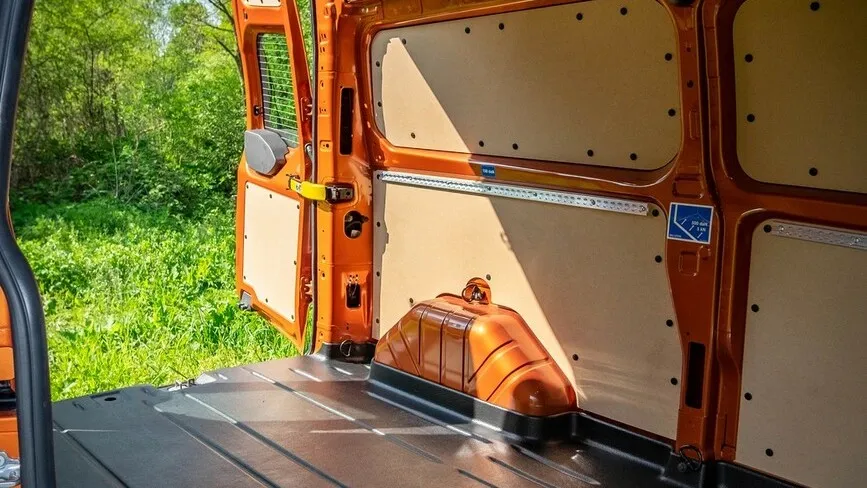 Innenraum des Ford Transit Custom mit geöffneten hinteren Türen und Blick nach draußen.