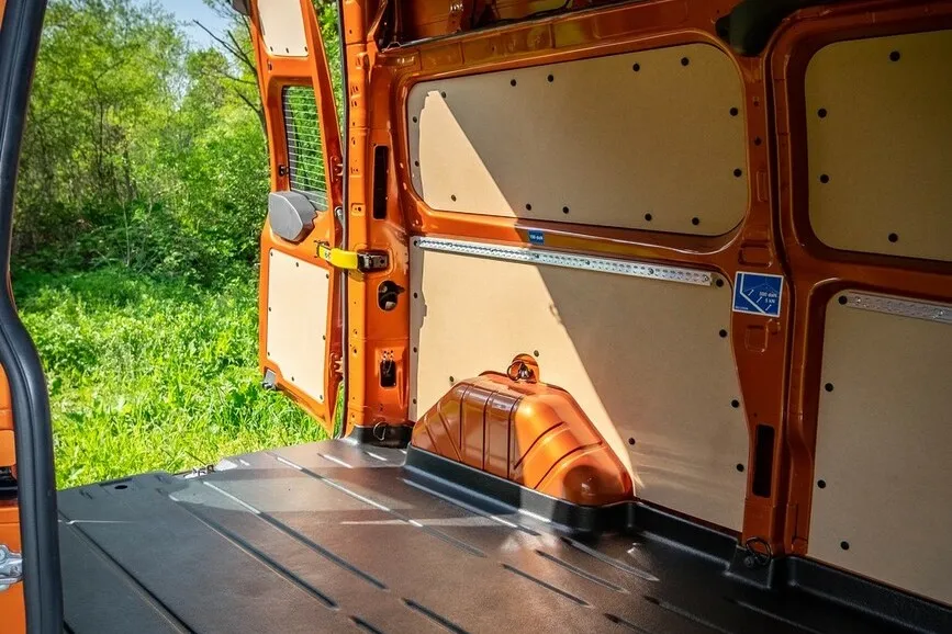 Innenraum des Ford Transit Custom mit geöffneten hinteren Türen und Blick nach draußen.