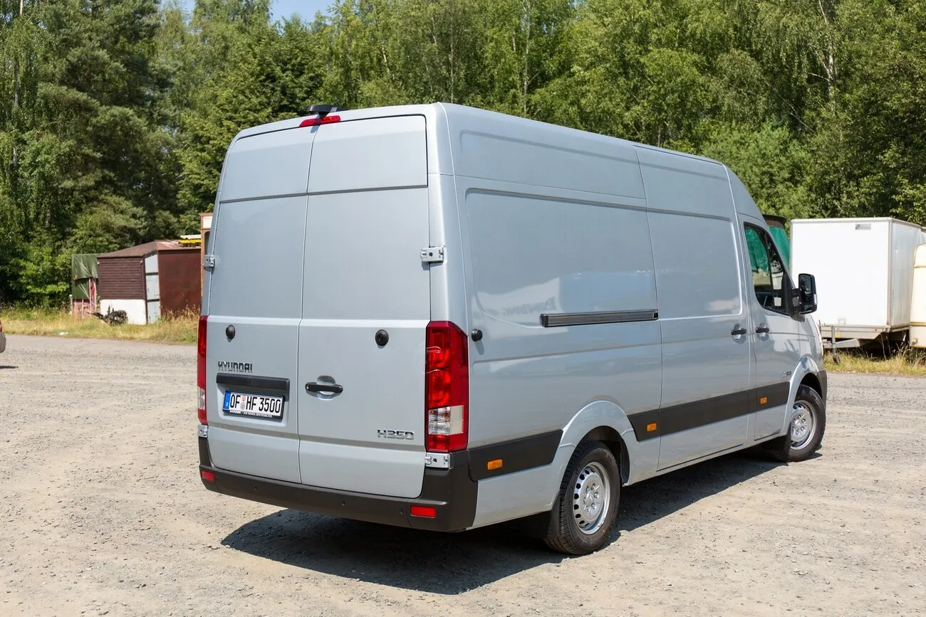 Der Hyundai H350 in silber. Blick schräg auf den hinteren Teil des Fahrzeugs.