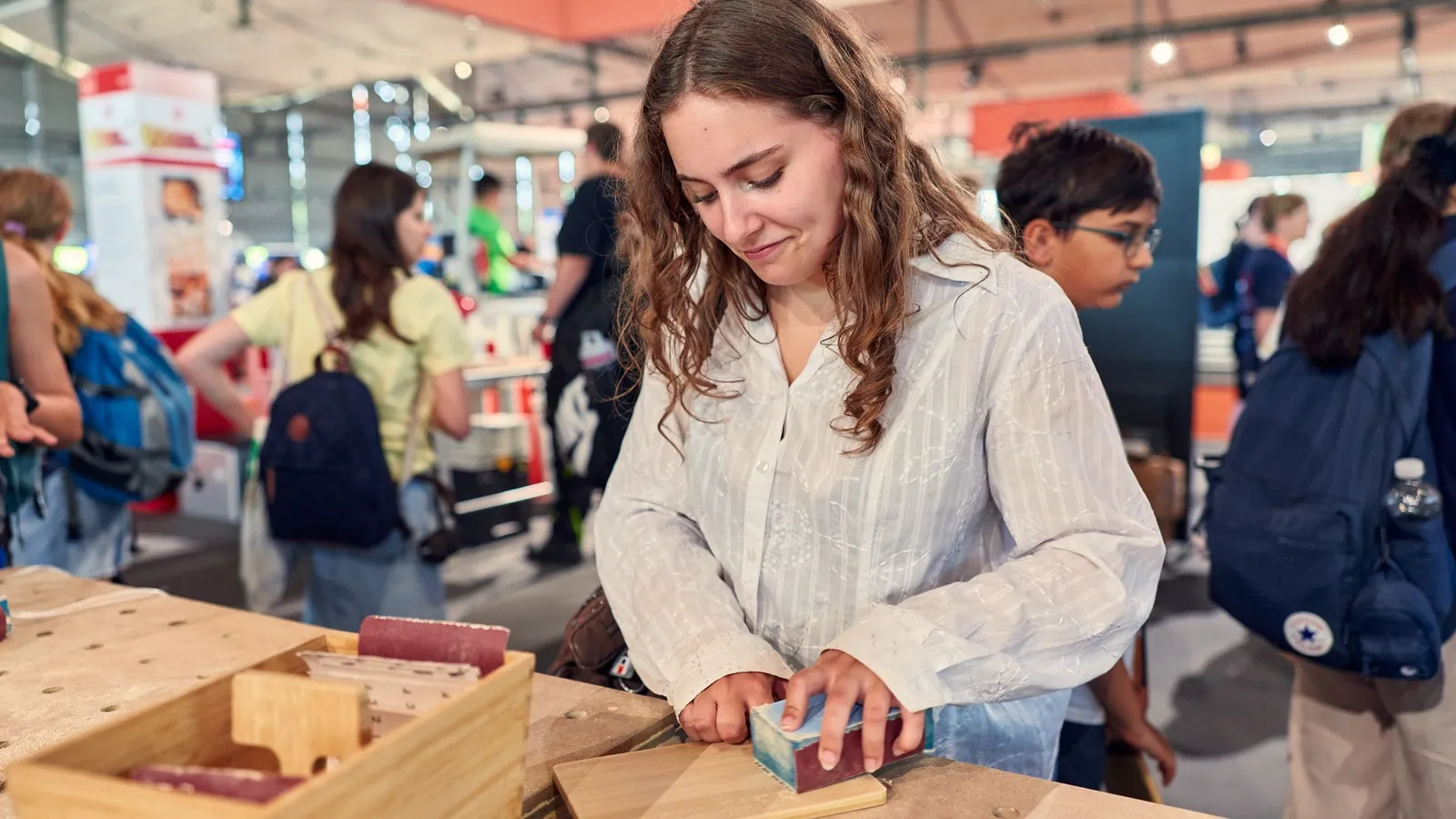 Mädchen probiert die Arbeit mit Holz auf der Ideenexpo