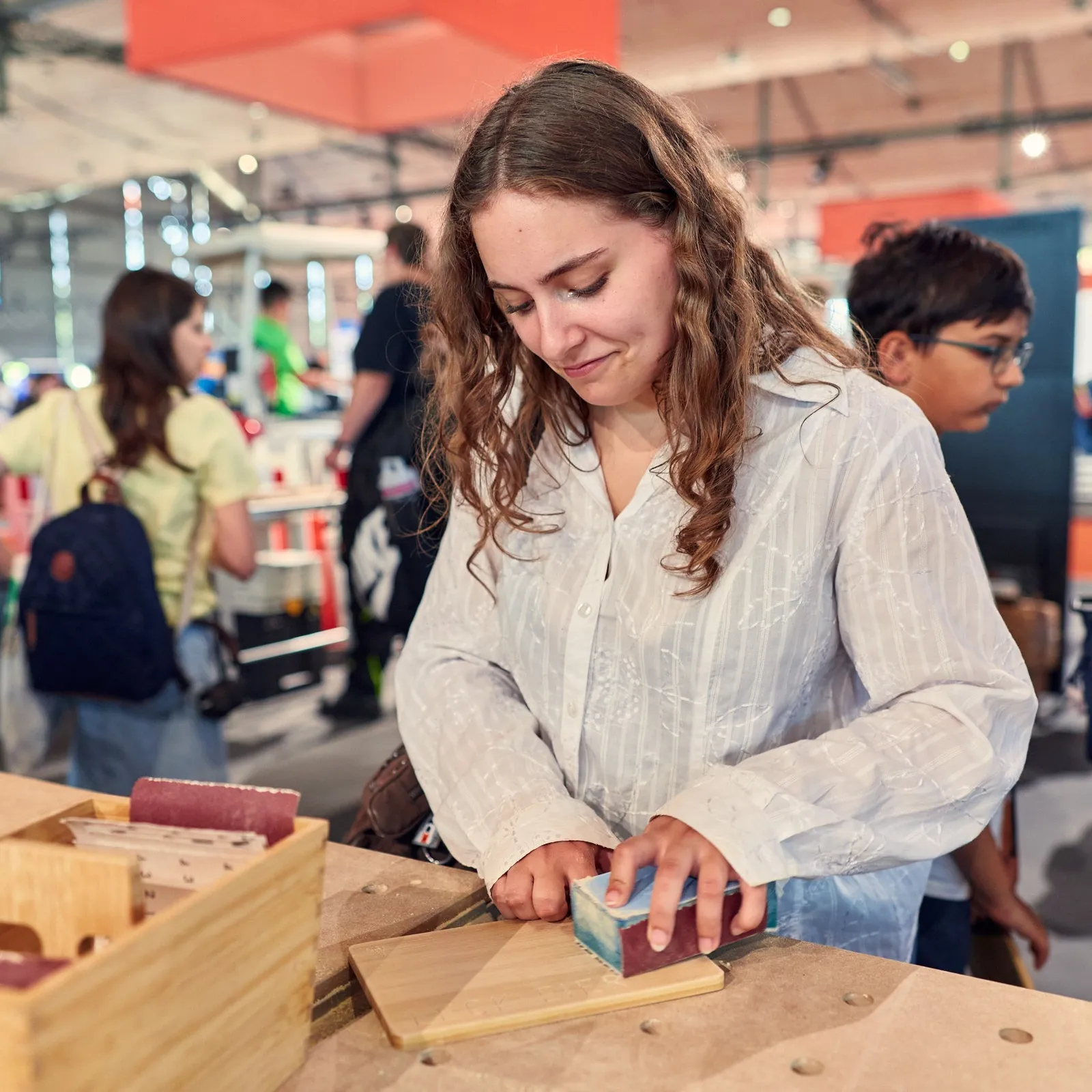 Mädchen probiert die Arbeit mit Holz auf der Ideenexpo