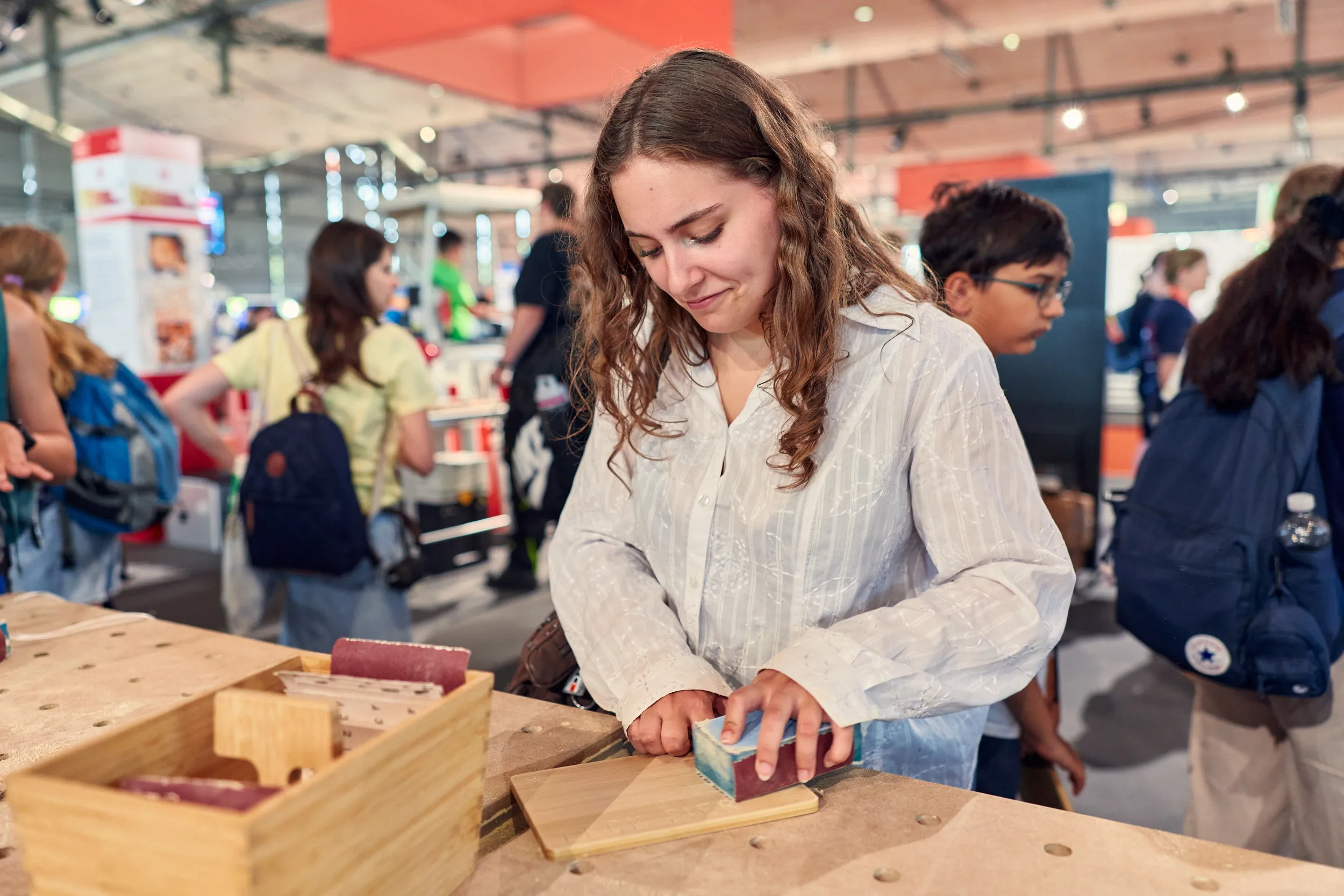 Mädchen probiert die Arbeit mit Holz auf der Ideenexpo