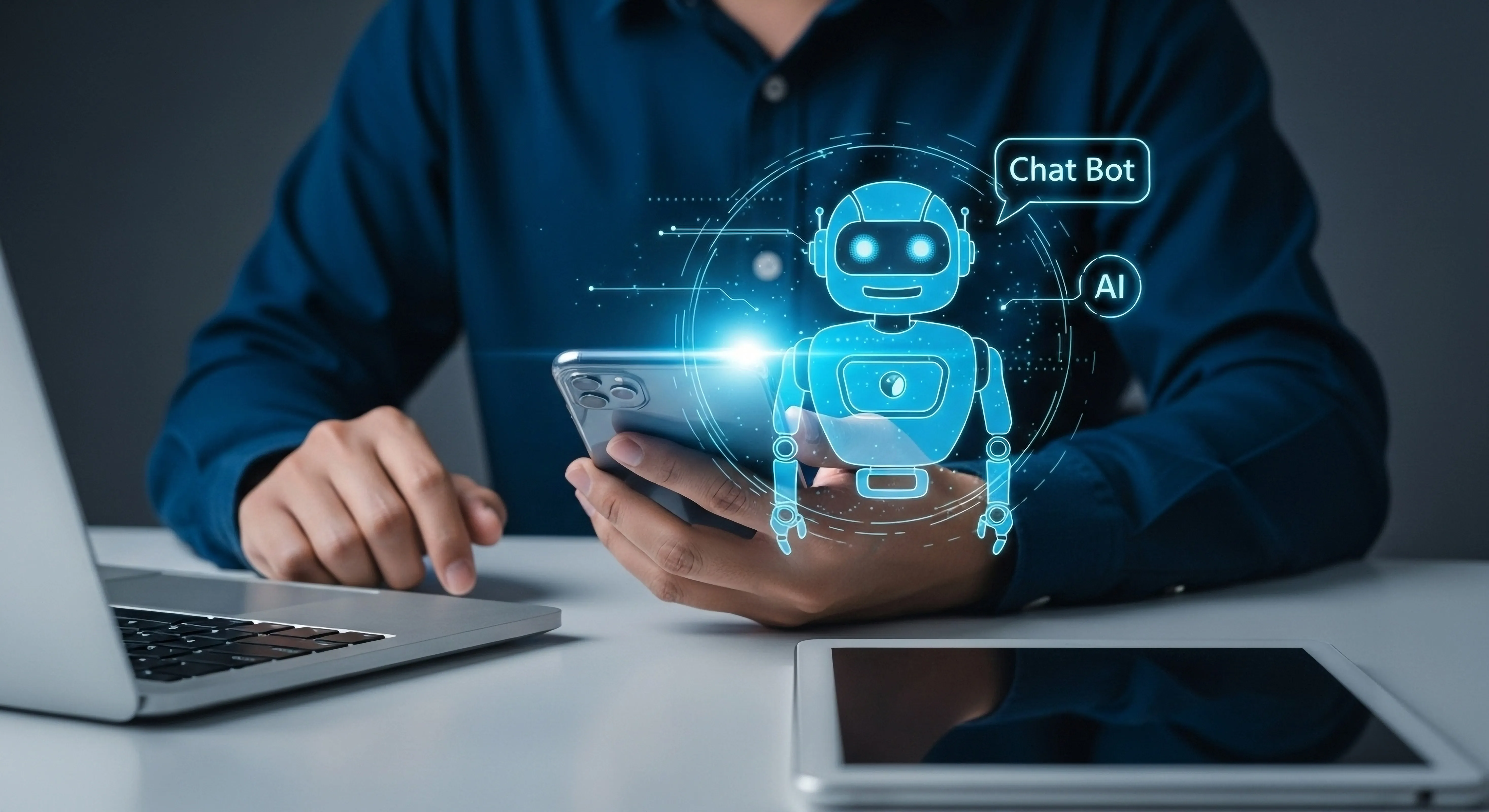 Eine Person sitzt am Laptop und hält gleichzeitig ein Smartphone in den Händen. Im Vordergrund des Fotos befindet sich ein zusätzliches grafisches Element: Hier wird ein Chatbot dargestellt, umgeben von leuchtenden blauen Linien.