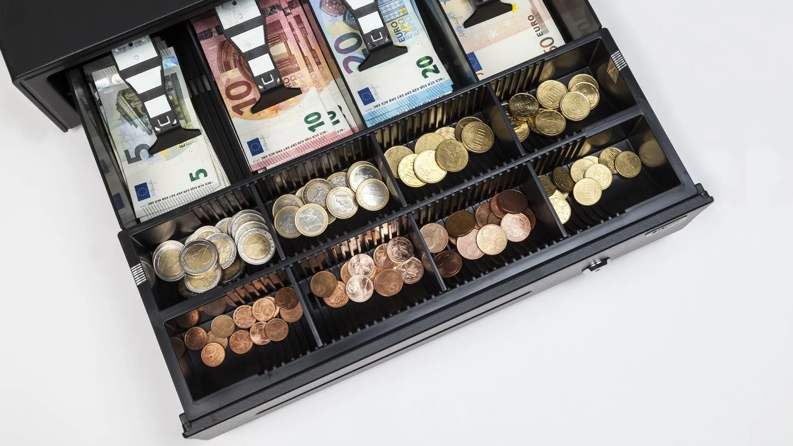 Ein Blick in eine Kasse mit mehreren Euro Scheinen und Münzen.
