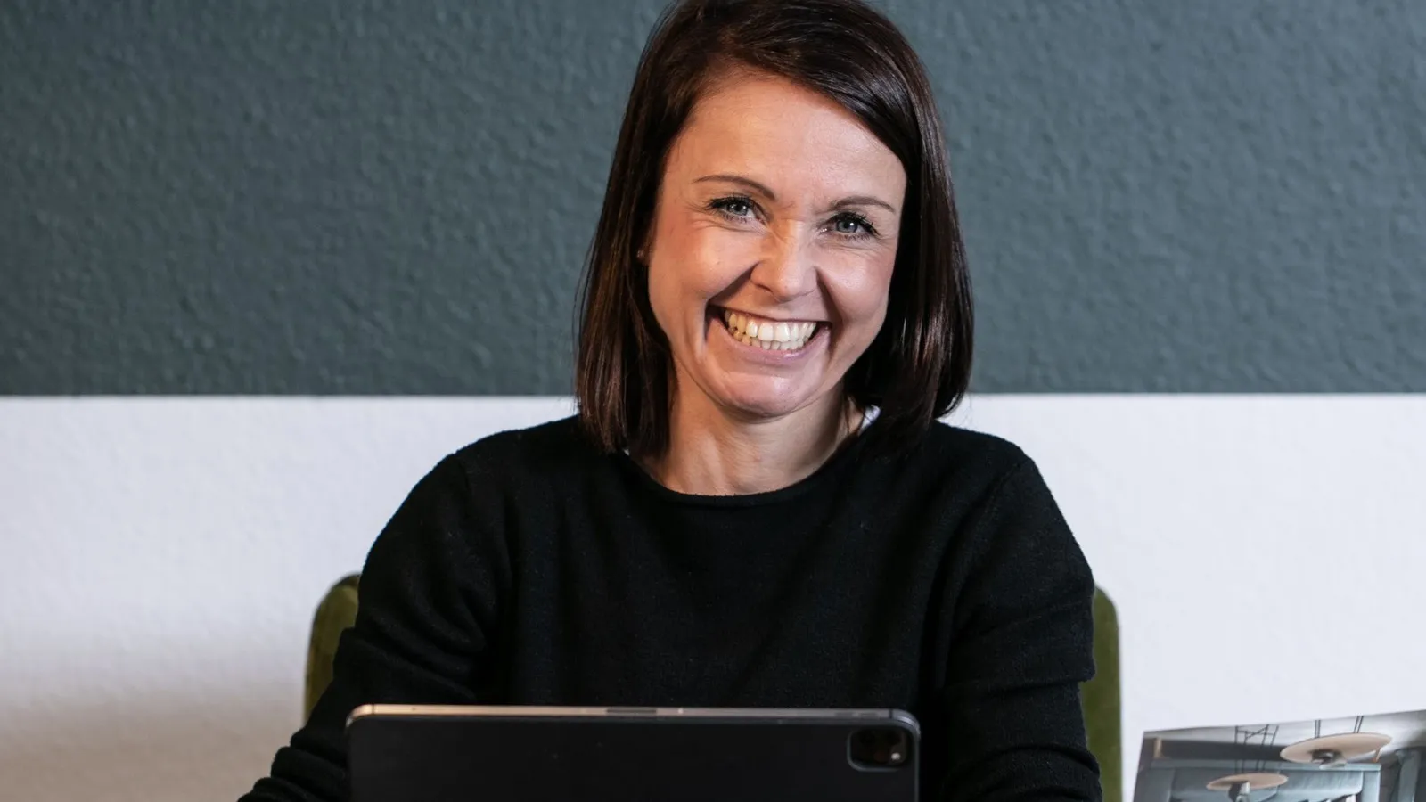 Raumausstattermeisterin Katja Schulze an ihrem Arbeitsplatz mit einem iPad.