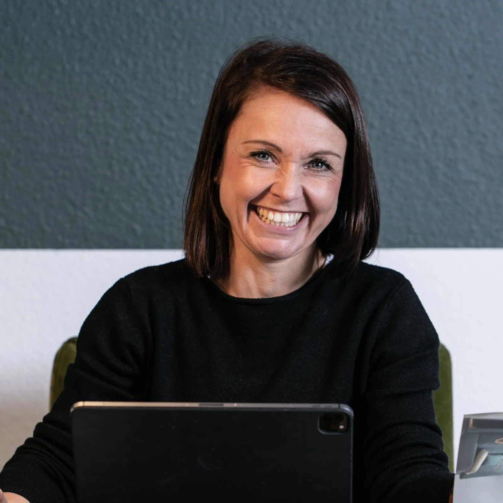 Raumausstattermeisterin Katja Schulze an ihrem Arbeitsplatz mit einem iPad.