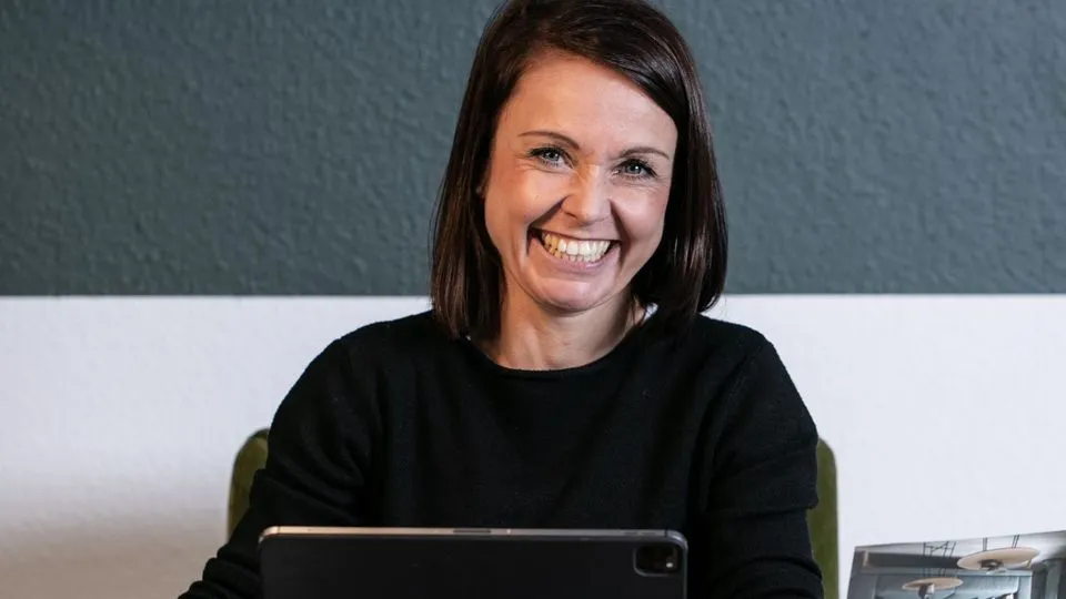 Raumausstattermeisterin Katja Schulze an ihrem Arbeitsplatz mit einem iPad.