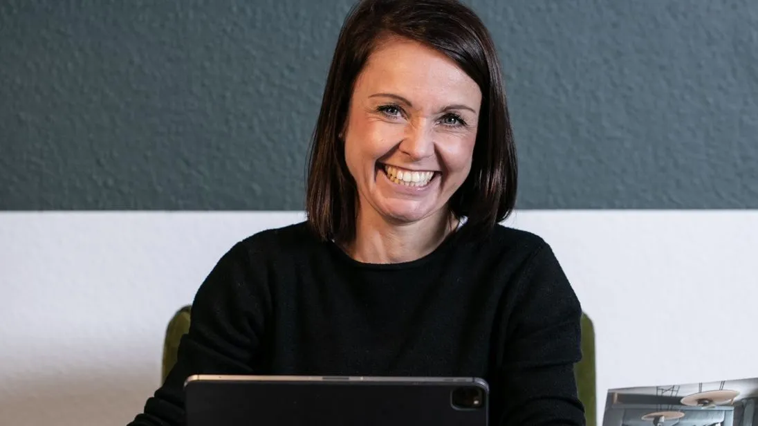 Raumausstattermeisterin Katja Schulze an ihrem Arbeitsplatz mit einem iPad.