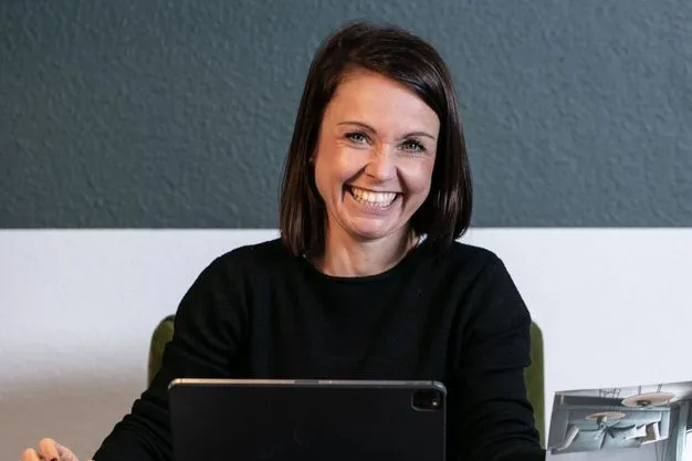 Raumausstattermeisterin Katja Schulze an ihrem Arbeitsplatz mit einem iPad.