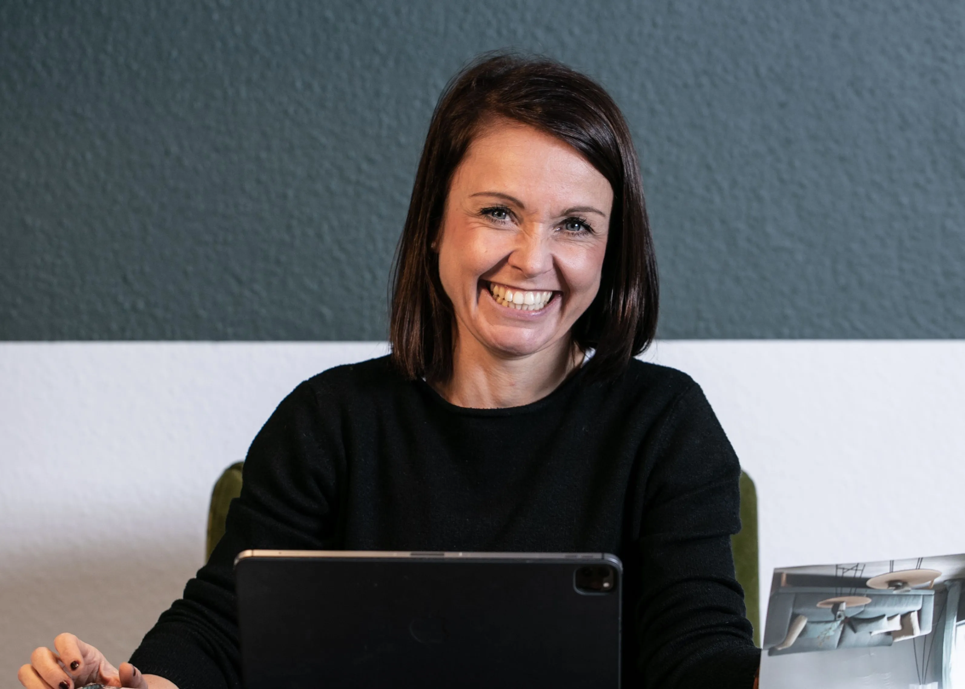 Raumausstattermeisterin Katja Schulze an ihrem Arbeitsplatz mit einem iPad.