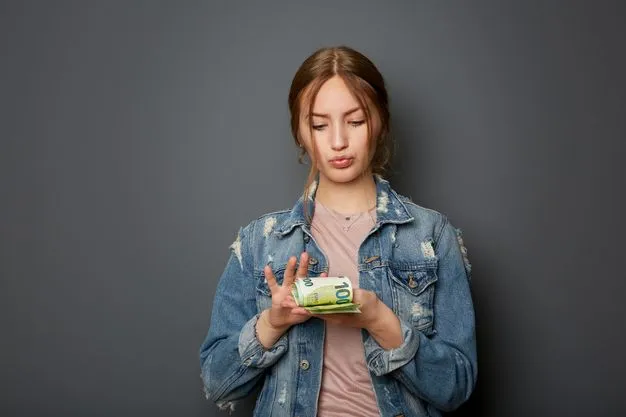 Eine Schülerin in Jeansjacke zählt ein Bündel Geldscheine. Dabei spitzt sie stolz die Lippen.