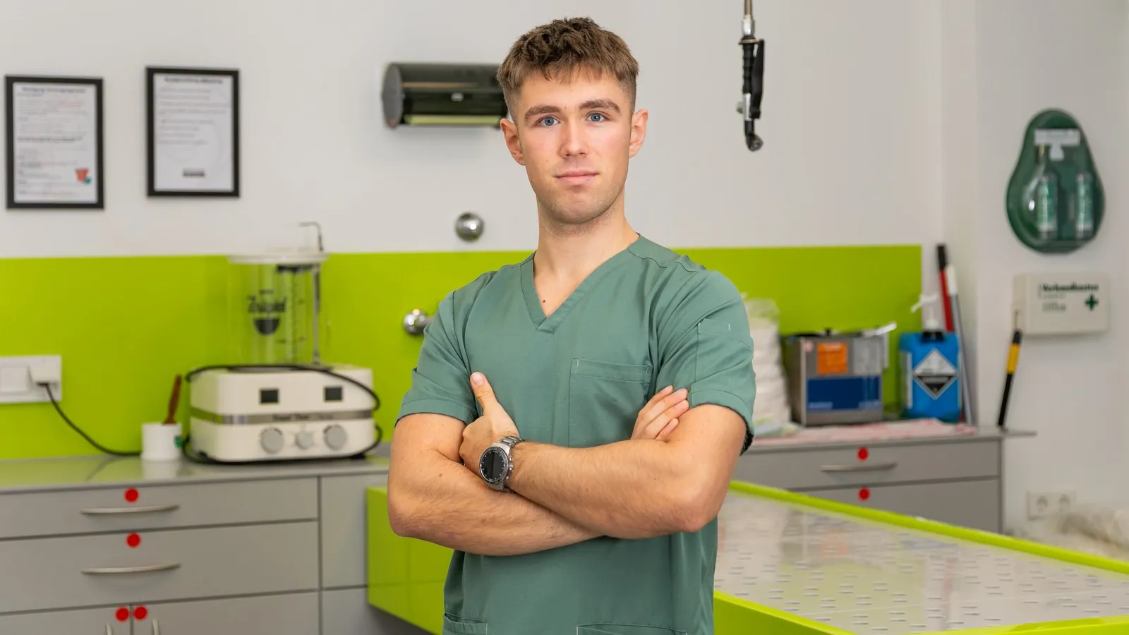 Der Bestatter Luis Bauer steht in einem Versorgungsraum des Bestattungsunternehmens. Hinter ihm ist ein leerer Tisch zu sehen.