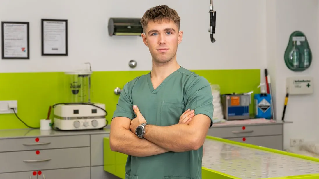Der Bestatter Luis Bauer steht in einem Versorgungsraum des Bestattungsunternehmens. Hinter ihm ist ein leerer Tisch zu sehen.